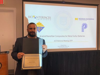 Ahmet Emre holding an award for ACS Excellence and Polymer Research