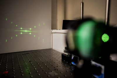 Green laser rays pointing at a wall